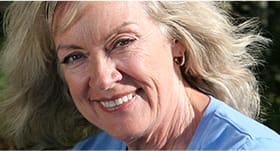 Older woman in light blue shirt grinning