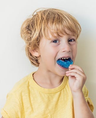 boy putting in blue mouthguard
