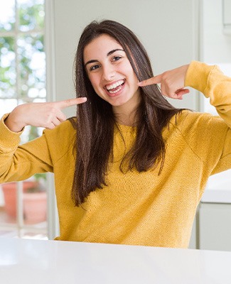 Teen pointing to her smile