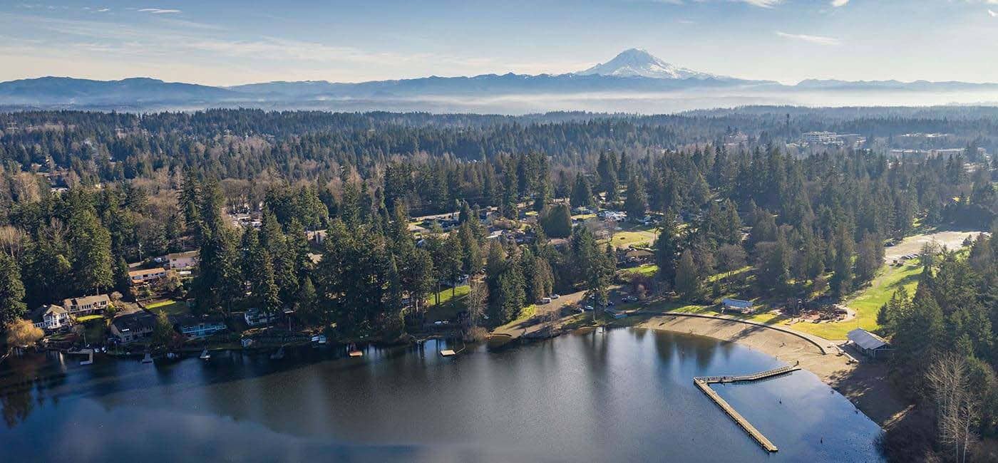 Overhead view of lake with forest and mountains in background