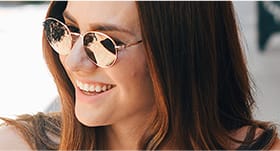 Smiling young woman wearing sunglasses outdoors