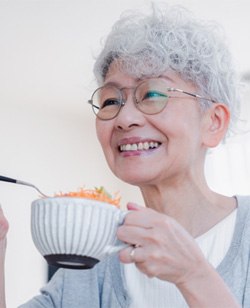 Woman eating with dentures in Federal Way  