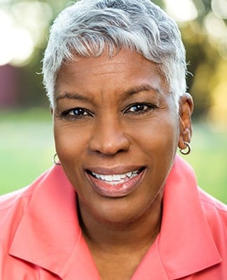 woman in coral shirt smiling