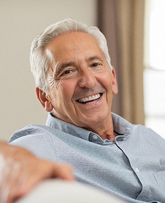 man smiling while sitting on couch 