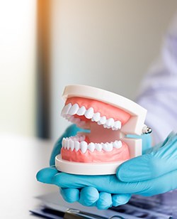 dentist holding dentures in hand 