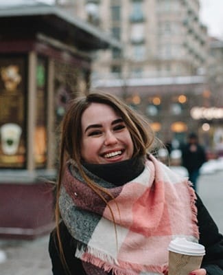 person in the city holding a cup of coffee