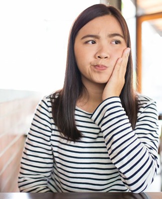 Pained woman wondering if she should visit her Federal Way emergency dentist