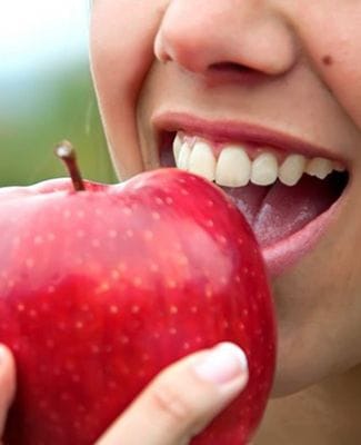 person biting into a red apple