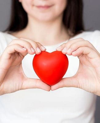 woman holding a red love heart in her hands