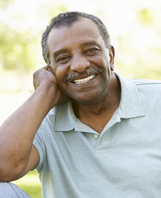 Man in grey polo outside smiling with dental implants in Federal Way