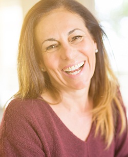 Woman in burgundy sweater smiling with natural lighting