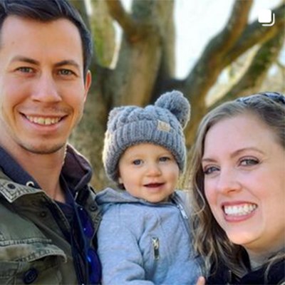 Mother and father holding their baby outdoors