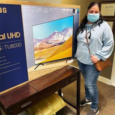 Woman standing next to large television in Federal Way