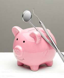 two dental instruments leaning against a piggy bank