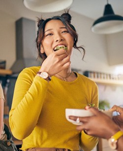 Group of friends smiling and eating together at home