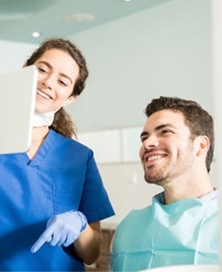 Dentist showing patient image on tablet