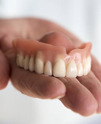 hand holding top denture