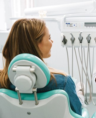 Smiling dentist taking notes on clipboard