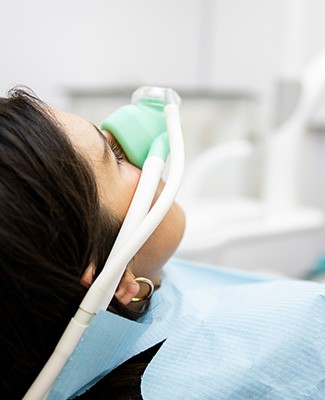 Patient breathing in nitrous oxide in treatment chair