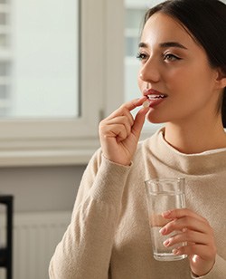 Woman with a pill and water