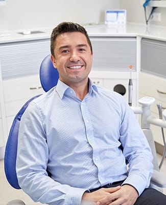 man in blue button down smiling