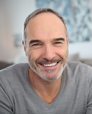 man in grey shirt smiling