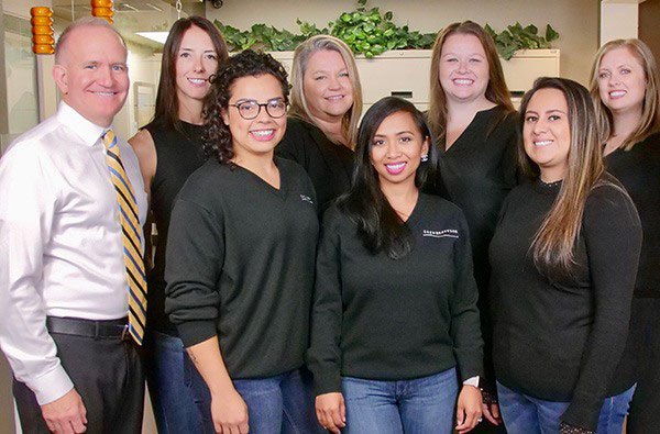 Federal Way dentist and team members smiling in dental office