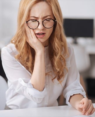 woman with circle glasses in pain