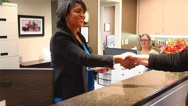 Dental team member shaking hands with patient in Federal Way dental office