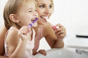 Parent and child brushing their teeth