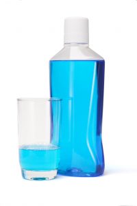 bottle of blue mouthwash glass