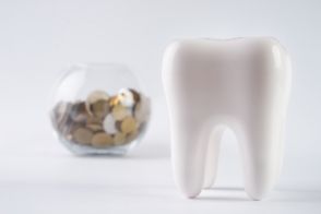 3D model of a tooth next to a jar of coins