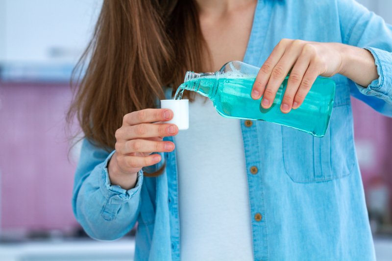 Woman pouring mouthwash into cap