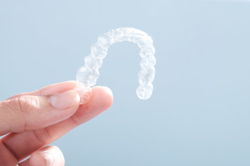 patient holding Invisalign aligner