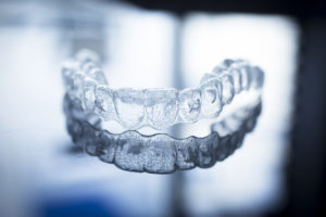Invisalign aligner on blue gray background