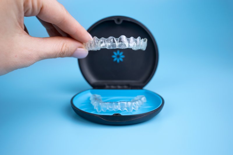 A woman holding mail-in clear aligners