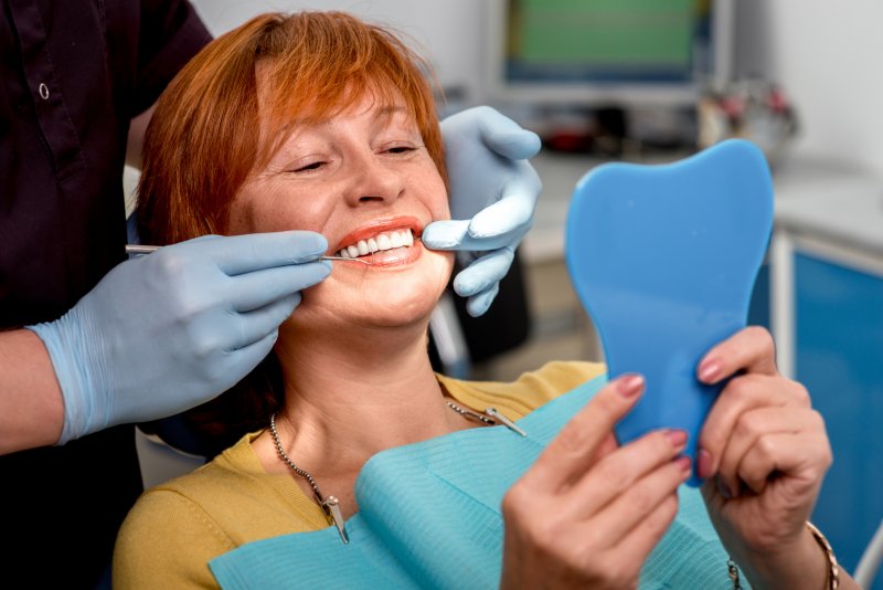 An older woman smiling at her new dental implants