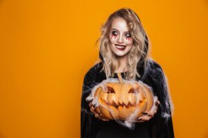 Woman smiling while holding a pumpkin