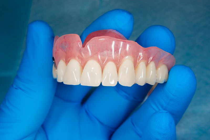 A hand holding a denture